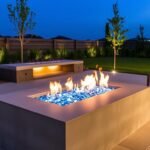 A sleek rectangular gas fire pit with glass rocks embedded in a concrete patio with modern outdoor furniture