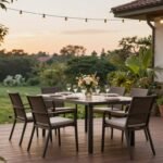 A beautiful patio dining set arranged on a wooden deck with string lights overhead and lush greenery surrounding it
