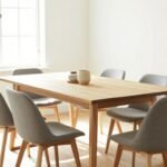 A beautifully designed dining area featuring a wooden rectangular dining table with stylish chairs in a bright, airy space