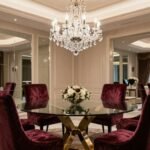A glamorous dining room with crystal chandelier, mirrored elements, and plush seating showcasing dining room glam style