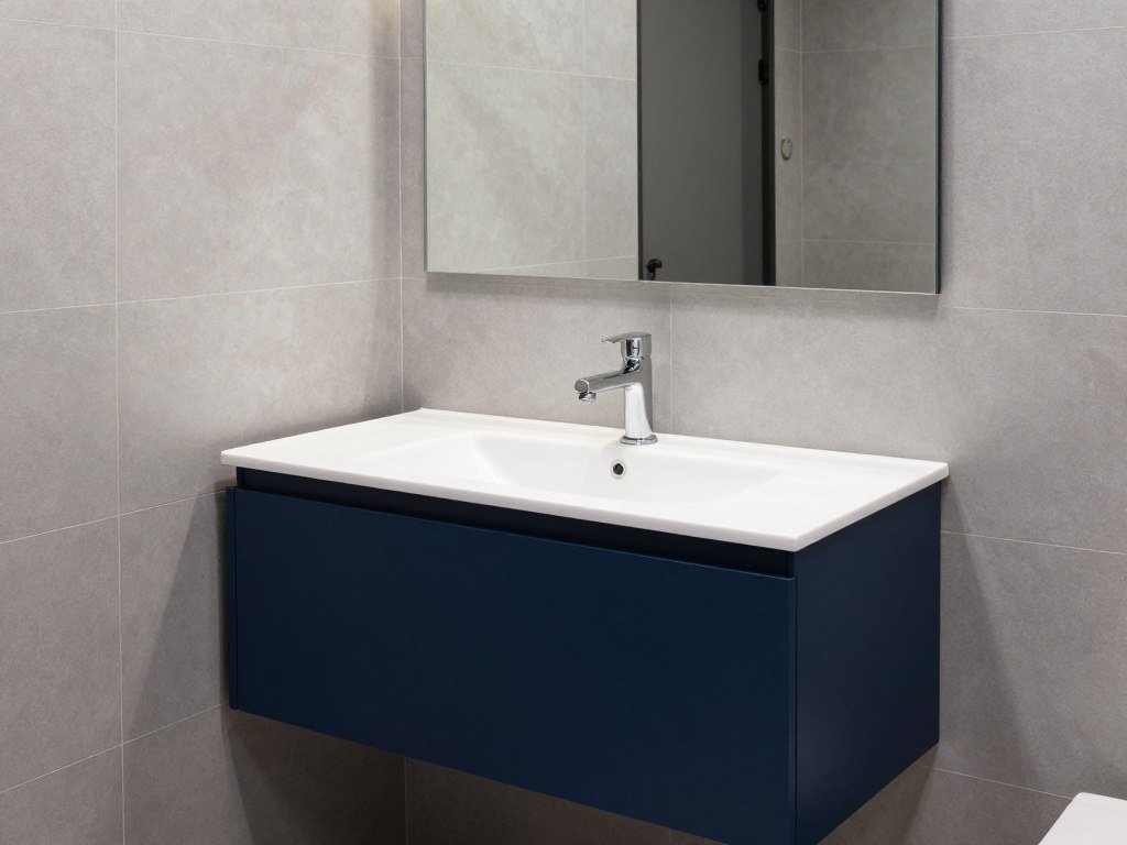 A modern floating blue bathroom vanity with minimalist design