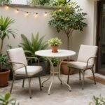 A small bistro set with two chairs and a round table on a compact patio with potted plants