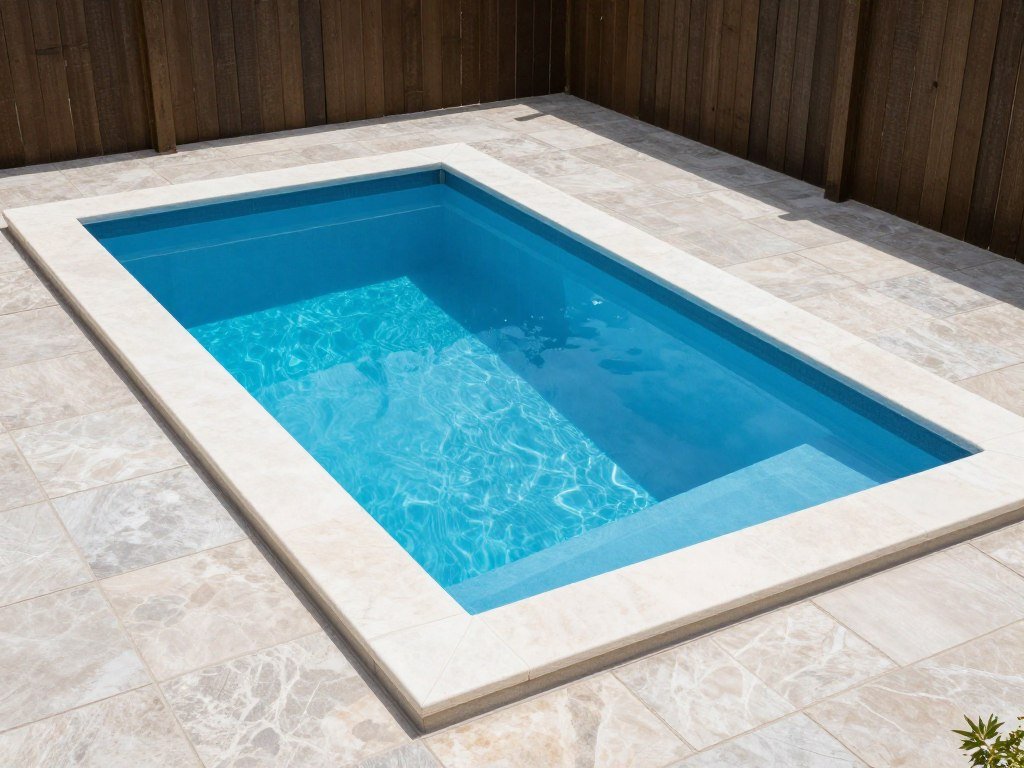 A small vinyl liner pool with modern coping in a compact backyard space