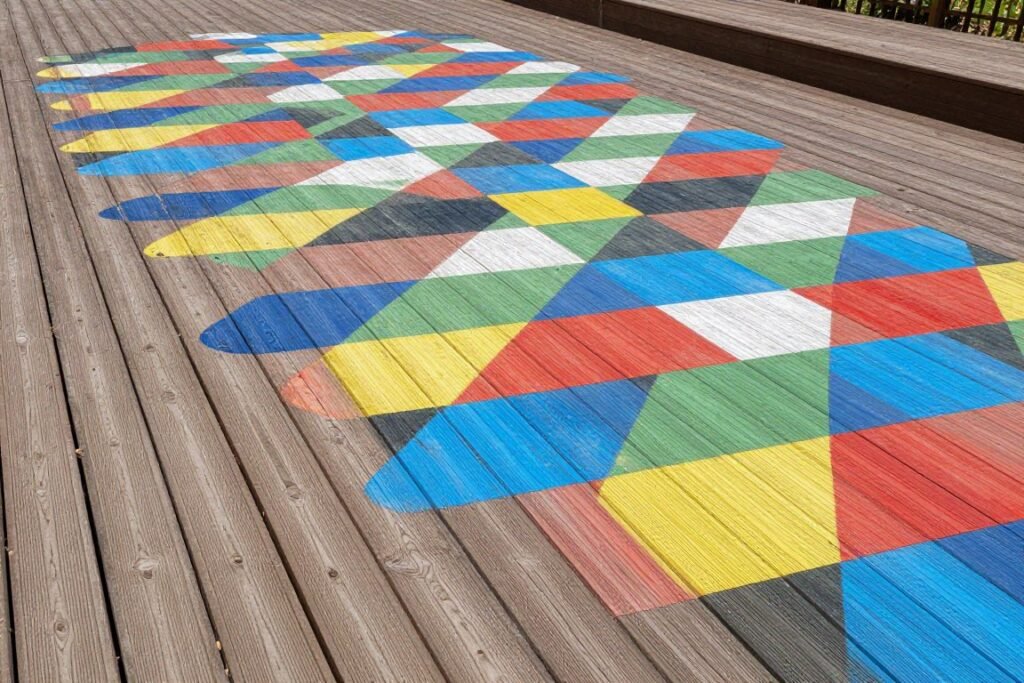A wooden deck with a painted mural in bright colors and patterns A wooden deck with a painted mural in bright colors and patterns