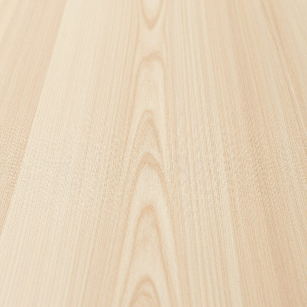 Close-up of a maple dining room table surface showing its smooth, light-colored grain