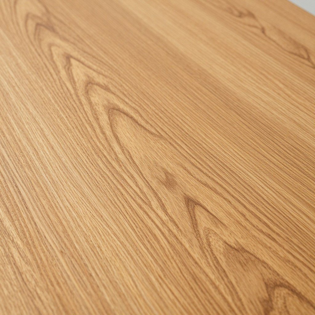 Close-up of an oak dining room table surface showing the beautiful natural grain pattern