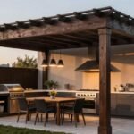 Dark Pergola Creates Cozy Outdoor Kitchen Entertaining Space Dark pergola creating a cozy atmosphere over an outdoor kitchen with pendant lights and comfortable seating