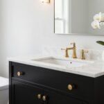 Modern black bathroom vanity with white marble countertop and gold hardware in a bright bathroom