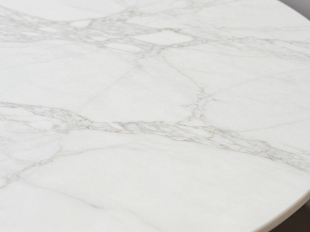 White marble dining table top showing natural veining patterns White marble dining table top showing natural veining patterns