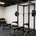A well-organized garage gym with weight rack, cardio equipment, and rubber flooring