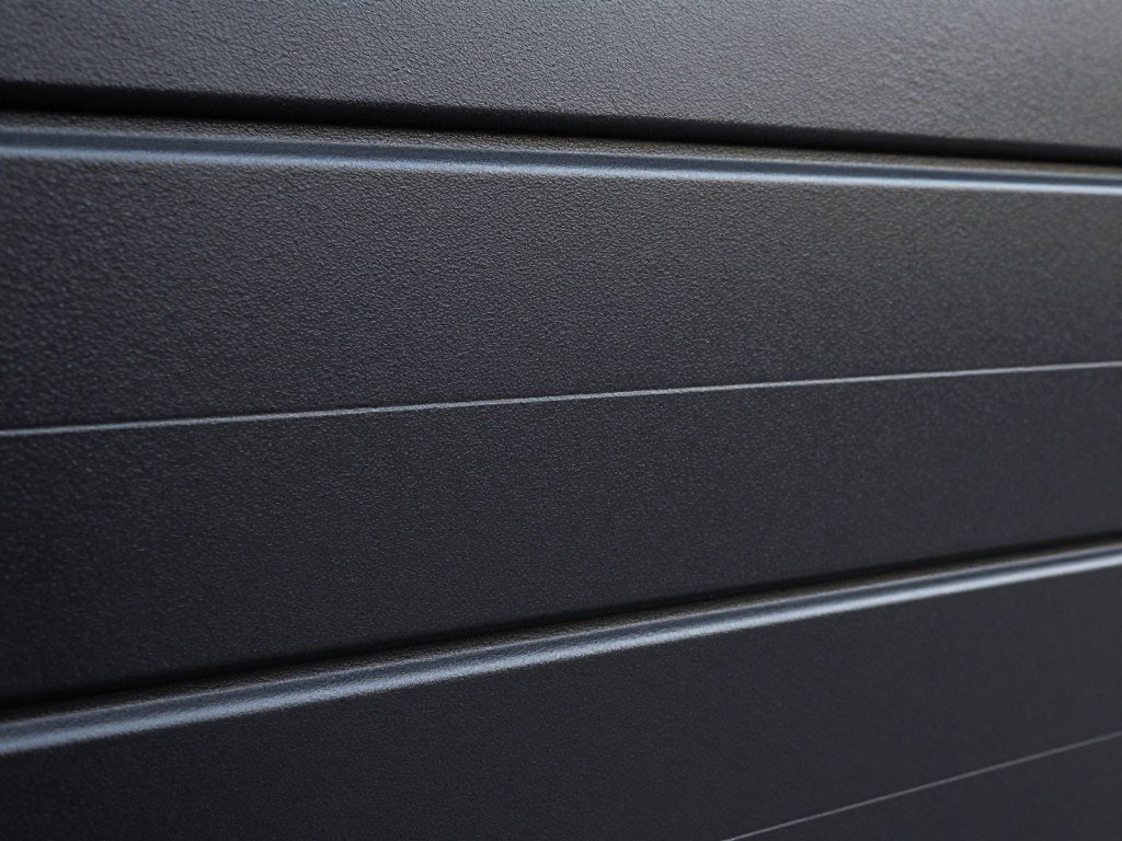 Black steel garage door with panels showing texture and finish