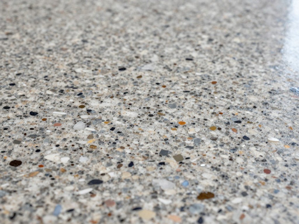 Close-up of epoxy garage floor with decorative flakes showing texture and depth Close-up of epoxy garage floor with decorative flakes showing texture and depth