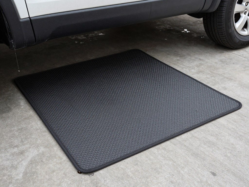 Heavy-duty garage floor mat under a vehicle catching oil drips