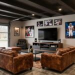 Modern garage man cave with comfortable seating, entertainment center, and sports memorabilia on the walls