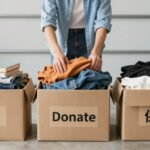 Person sorting items into labeled boxes for garage sale preparation