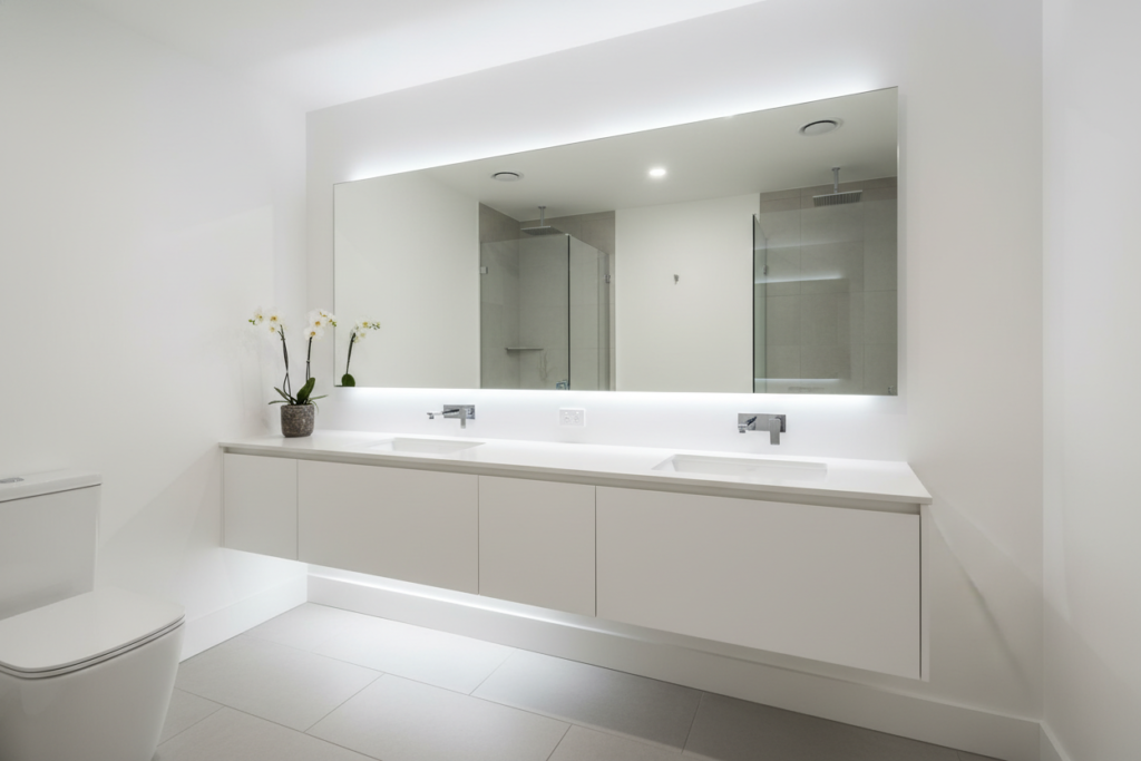 Large mirror reflecting small bathroom making space appear larger