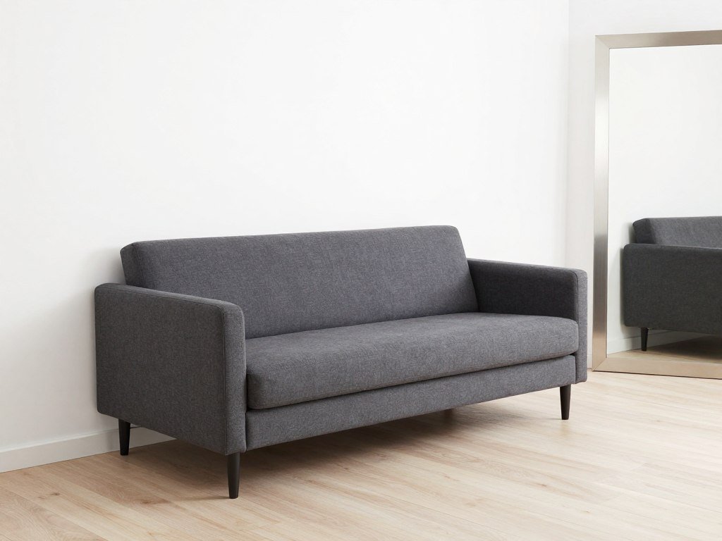 charcoal sofa bed in small room with light walls