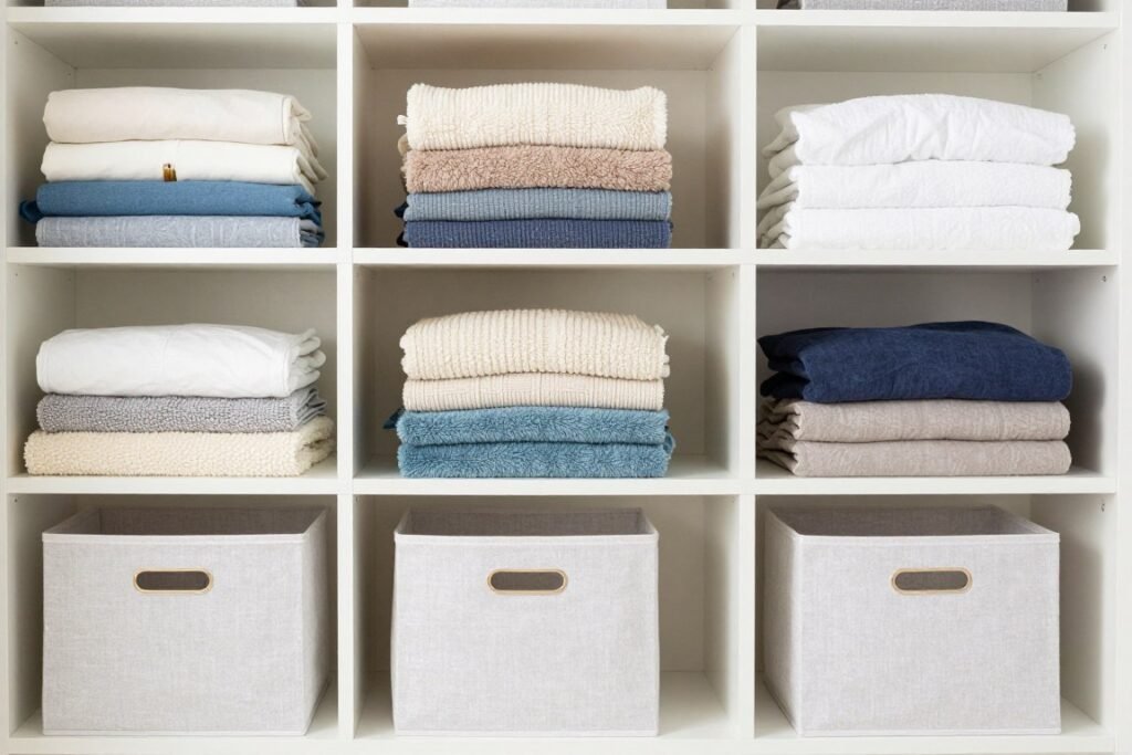 organized linen closet with folded blankets on shelves