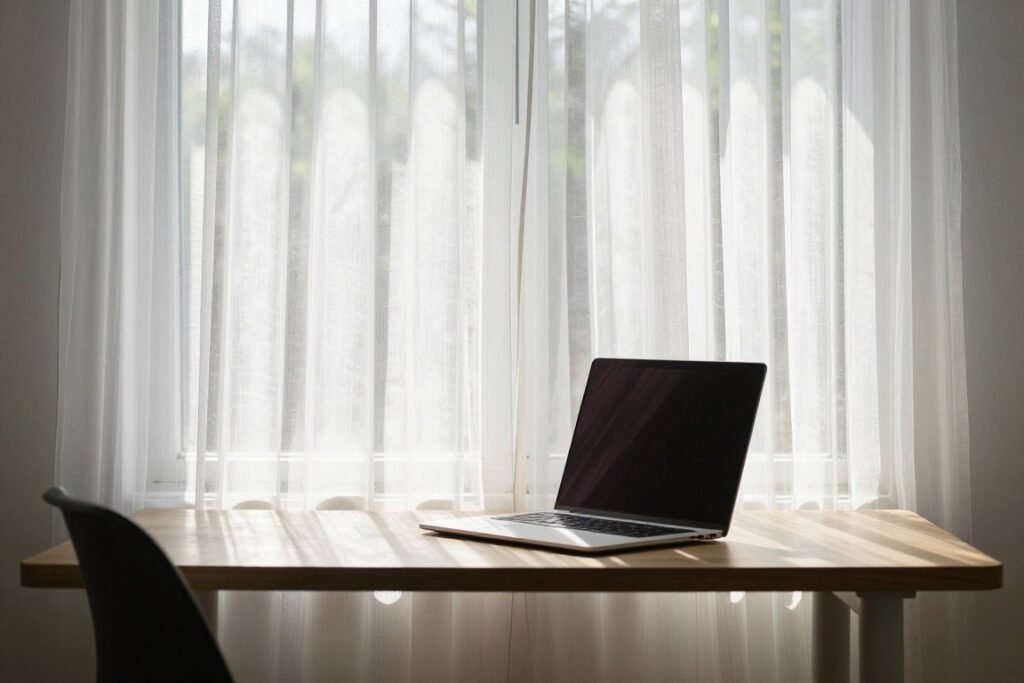 small desk with sheer curtains filtering summer sunlight